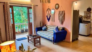 una sala de estar con un sofá y una mesa en Dreamy Boho Haven Vagator, en Anjuna