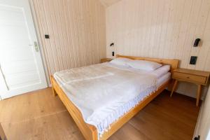 a small bedroom with a bed with a wooden frame at Domki letniskowe w Centrum Rekreacji i Wypoczynkou Deczno in Sulnówko