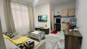 a small living room with a couch and a kitchen at Kiambu road Green Zone Macedonia in Kiambu