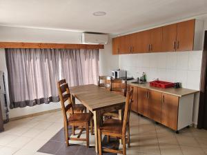 a kitchen with a wooden table and chairs and a counter at Traflor Termhouse in Venus