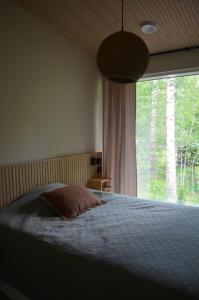 Un dormitorio con una cama y una ventana grande. en Villa Jade, en Lohja