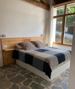 a bedroom with a bed with a wooden headboard and a window at Casa costa de Lugo frente al mar in Nois