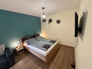 ein Schlafzimmer mit einem Bett und einem Fernseher an der Wand in der Unterkunft Hanna Apartman in Debrecen + 17 Fotos