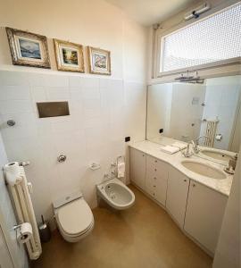 a bathroom with a toilet and a sink and a mirror at Art & Lake Apartment in Lecco +22 photos