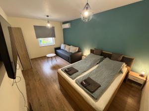 ein Schlafzimmer mit einem großen Bett und einer Couch in der Unterkunft Hanna Apartman in Debrecen
