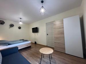 ein Schlafzimmer mit einem Bett, einem Tisch und einem Fernseher in der Unterkunft Hanna Apartman in Debrecen