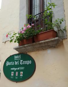 a sign on a building with plants on a window at Porta Del Tempo in Stroncone