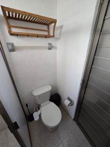 a small bathroom with a toilet and a shower at Comoda Suite Privada in Cancún +1 photo
