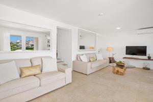 a living room with two white couches and a tv at Apartamento frente al mar en Binibeca Nou in Binibeca
