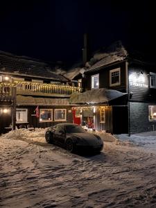 a car parked on a snow covered street at night at BUDGET Kvamseter Lodge in Eikjedalen