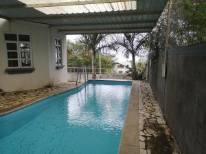 a swimming pool in a backyard with a pergola at La Gaulette Seaview Villa in La Gaulette