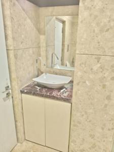 a bathroom with a sink and a mirror at Vilva Town House in Chennai