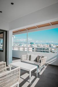 a living room with a couch and chairs on a balcony at Amber View Penthouse 220sqm- overlooking downtown in Limassol