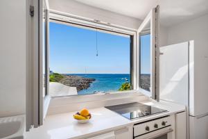 a kitchen with a large window with a view of the ocean at Apartamento frente al mar en Binibeca Nou in Binibeca +20 photos