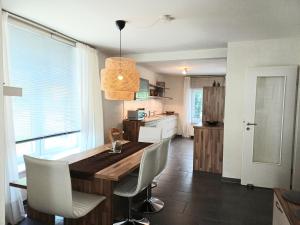 a kitchen and dining room with a wooden table and chairs at Ferienwohnung Lampe in Bad Essen