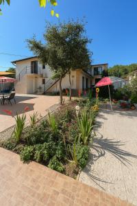 a garden in front of a house with an umbrella at Casa Maxim Eforie Nord in Eforie Nord