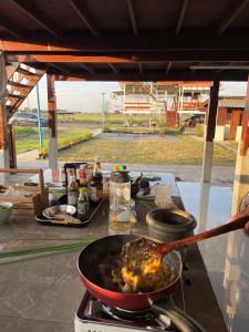 una sartén de comida está cocinando en una estufa en BanYat Farm Stay, 