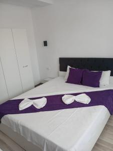 a bed with bows on it with purple and white sheets at Vila Atlas Constanta in Constanţa +23 photos
