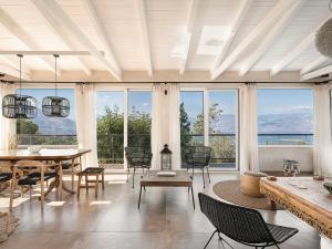 a living room with a table and chairs and large windows at Rosmarino Villa Galaxidi in Galaxidhion +51 photos