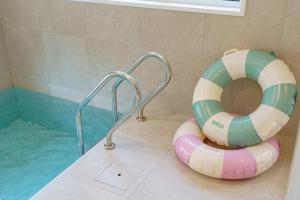 a bath tub with a life vest next to a pool at Chuncheon Wolhadam Pool Villa in Chuncheon