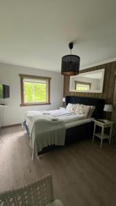 a bedroom with a bed and a mirror and a chair at BUDGET Kvamseter Lodge in Eikjedalen