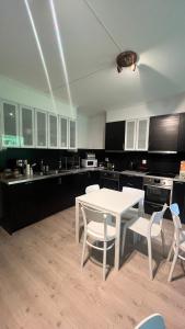 a kitchen with a white table and white chairs at BUDGET Kvamseter Lodge in Eikjedalen