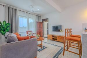 ディアニ・ビーチにあるMarahaba Holiday Suitesのソファとテレビのあるリビングルーム