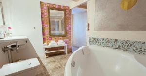 a bathroom with a tub and a sink and a mirror at AjoieSpa in Porrentruy