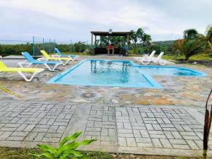una piscina con sedie e un gazebo di Belle Etoile Océan a Rodrigues Island