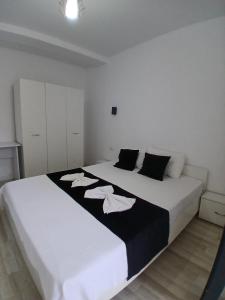 a bedroom with a large white bed with towels on it at Vila Atlas Constanta in Constanţa
