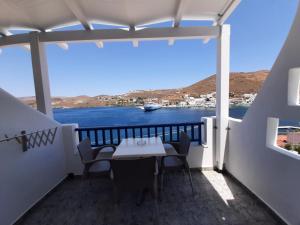 a balcony with a table and chairs and a view of the water at Romantza δωμάτιο 4 in Mérikhas