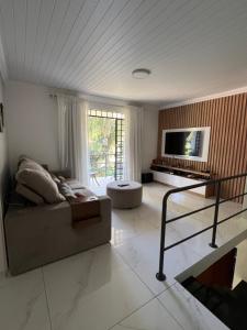 a living room with a couch and a tv at Refúgio na Capital in Curitiba