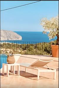 a room with a view of the ocean and a bench at Paulanni in Teulada