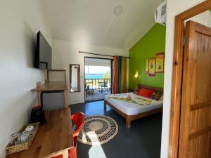 una stanza con un letto e un tavolo in una stanza di Belle Etoile Océan a Rodrigues Island