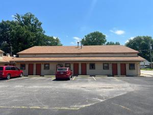 Un edificio con un coche rojo estacionado en un estacionamiento. en Hotel O Best Rest Inn Springfield US 36, en Springfield