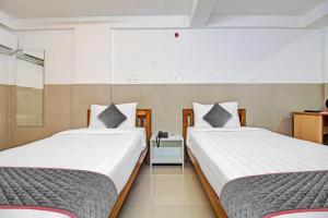 a bedroom with two beds and a table at Townhouse Empire Executive in Pune