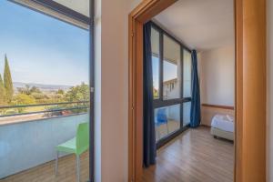 a door to a balcony with a view of a bedroom at Hotel Centro Turistico Gardesano in Bussolengo