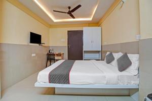 una camera da letto con un letto e un ventilatore a soffitto di Townhouse Empire Executive a Pune