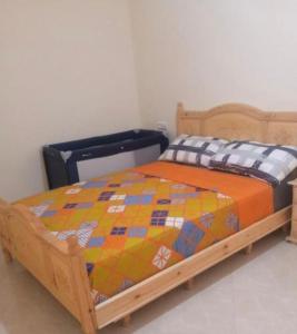 a bed with a quilt on it in a room at Hoceima in Al Hoceïma