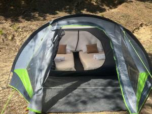 a tent with a bed in it on the ground at Camping Tent JUNIOR in Danilovgrad