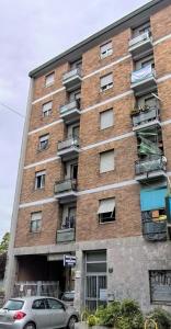 Un edificio de apartamentos con coches aparcados delante. en Milano Nord - Near the metro apartment, en Milán