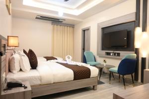 a hotel room with a bed and a flat screen tv at Hotel Kashi Crown in Varanasi +134 photos