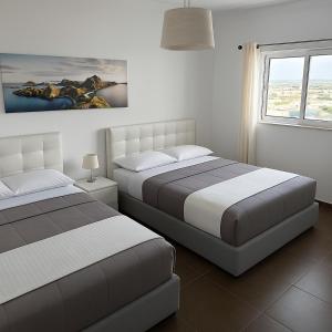een slaapkamer met twee bedden en een schilderij aan de muur bij Veduta Panoramika in Sliema