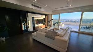 een woonkamer met een witte bank en grote ramen bij Veduta Panoramika in Sliema