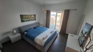 een slaapkamer met een blauw bed en een balkon bij Veduta Panoramika in Sliema +23 foto's