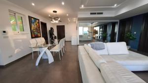 een woonkamer met een witte bank en een tafel bij Veduta Panoramika in Sliema