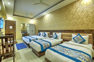 una camera con tre letti con lenzuola blu e bianche di Hotel Smart Lax a Nuova Delhi