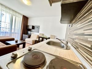 a kitchen with a sink and a living room at Menada Diamant Apartments in Sunny Beach