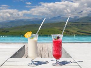 two cocktails sitting on a table next to the ocean at Cayley Mountain Resort in Champagne Valley +30 photos