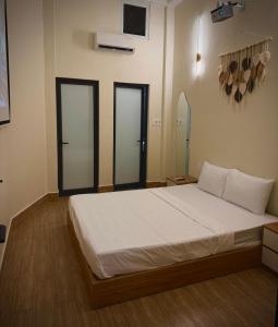 una camera da letto con un letto grande con due porte a vetri di Ngo Homestay a Hue